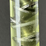 NYX Mod2 titanium K-baffle stack visible through clear acrylic display tube showing internal suppressor design
